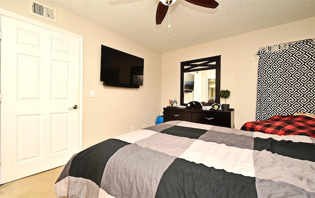 carpeted bedroom with a textured ceiling and ceiling fan