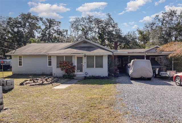 ranch-style home featuring a carport and a front lawn