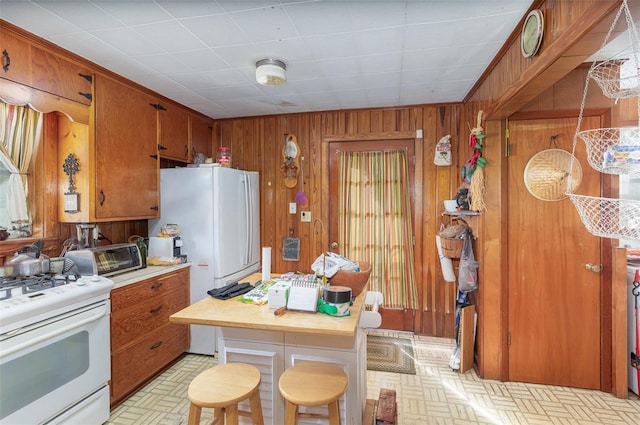 kitchen with wooden walls and white appliances