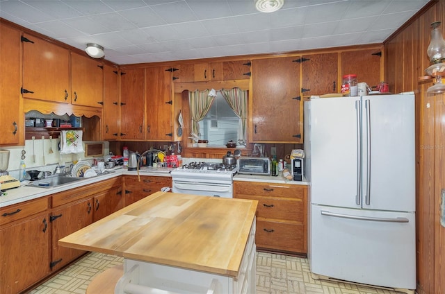 kitchen with butcher block counters, sink, and white appliances