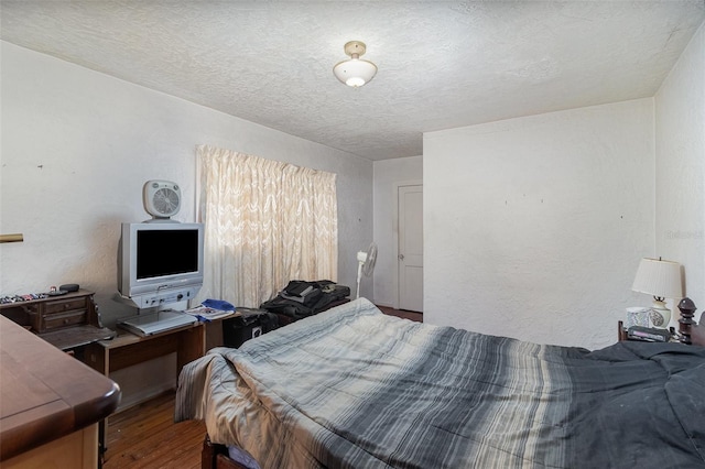 bedroom with wood-type flooring and a textured ceiling