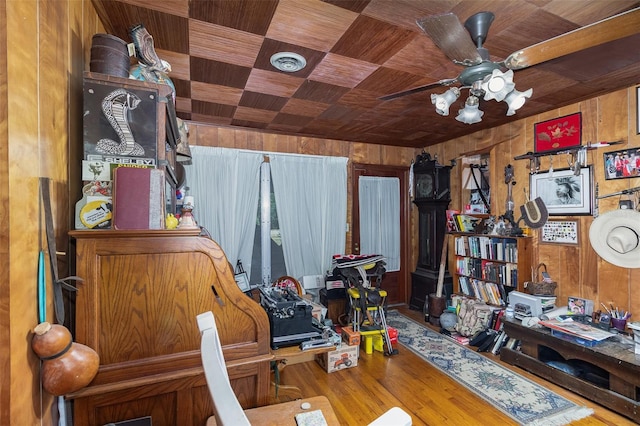 interior space with ceiling fan, wood-type flooring, wooden walls, and wooden ceiling