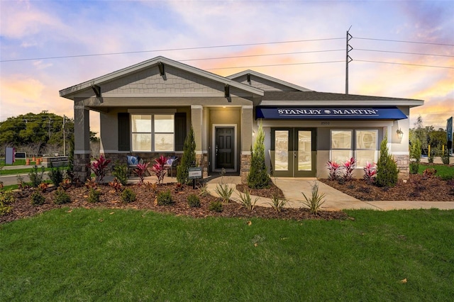 view of front of home featuring a lawn and french doors