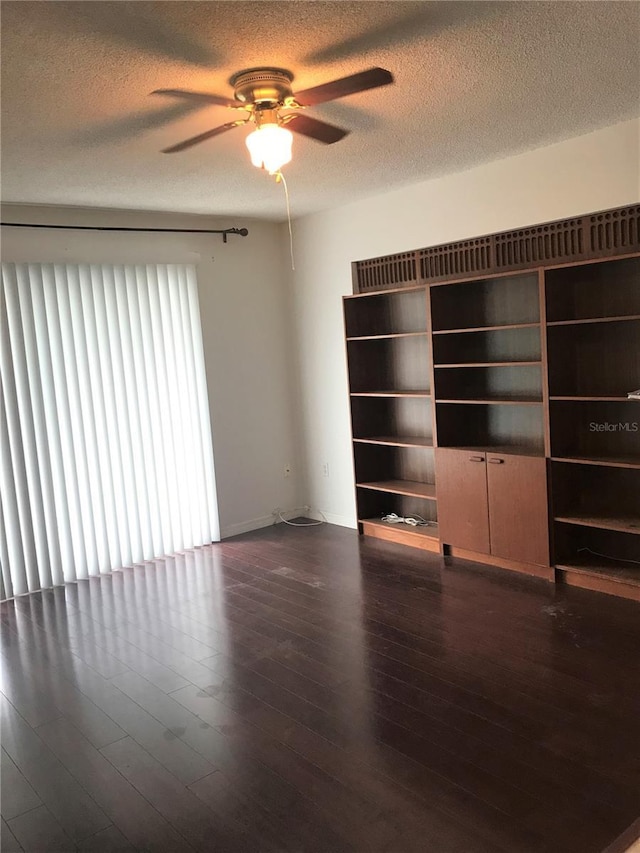 unfurnished living room featuring a textured ceiling, ceiling fan, and dark hardwood / wood-style floors