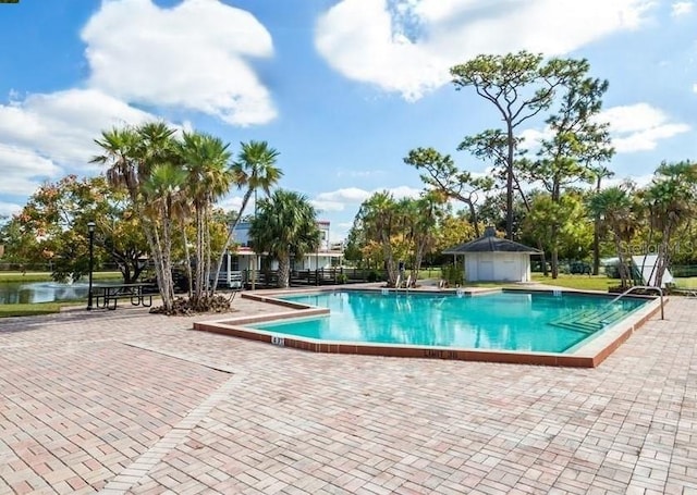 view of pool with a water view and a patio area