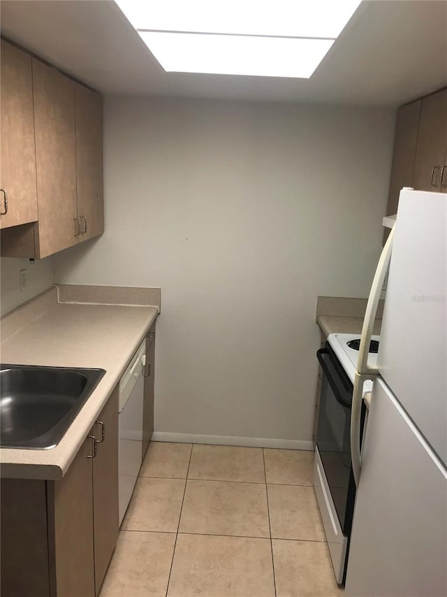 kitchen with light tile patterned floors, white appliances, and sink