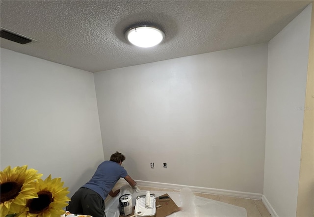 tiled spare room with a textured ceiling