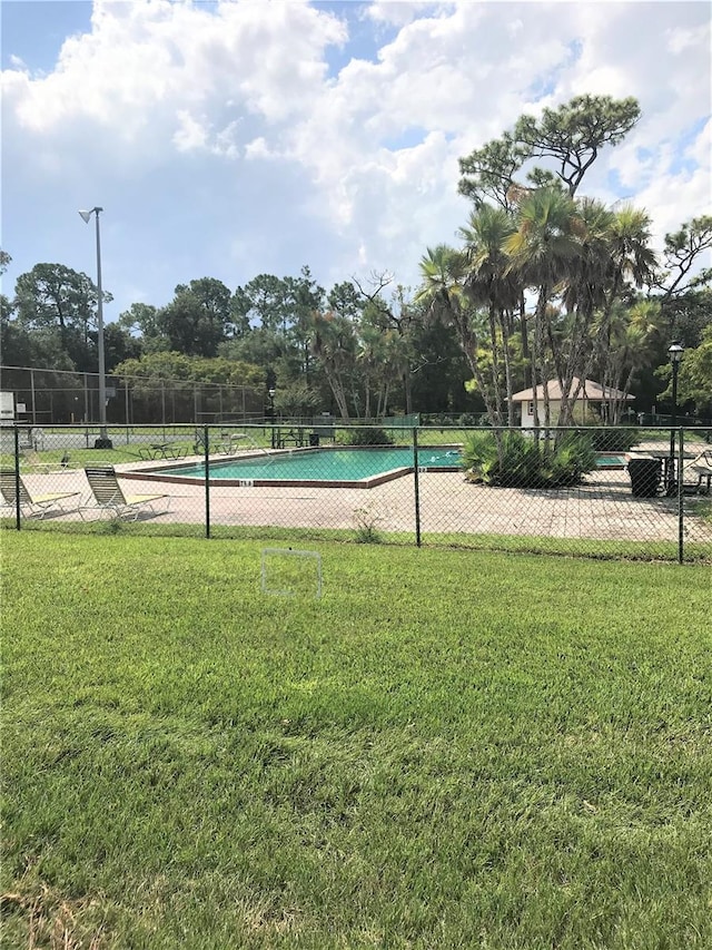 view of pool featuring a lawn