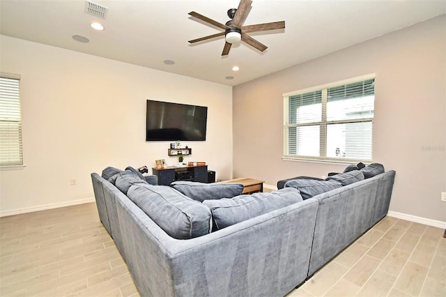 living room with light hardwood / wood-style floors and ceiling fan