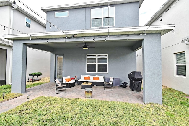 back of property with a yard, an outdoor hangout area, a patio, and ceiling fan