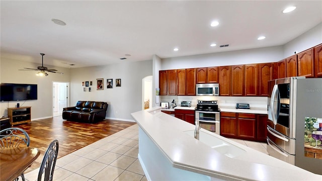 kitchen featuring ceiling fan, stainless steel appliances, and light tile patterned floors