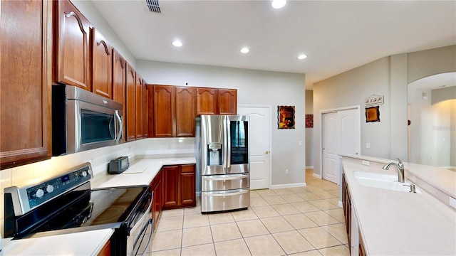 kitchen with light tile patterned flooring, appliances with stainless steel finishes, sink, and backsplash