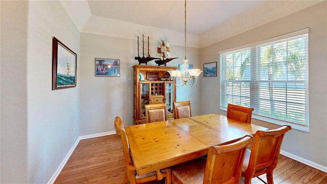 dining space featuring wood-type flooring, a chandelier, and a wealth of natural light