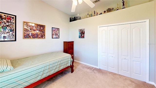 carpeted bedroom with ceiling fan and a closet