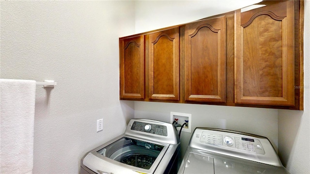 washroom with independent washer and dryer and cabinets