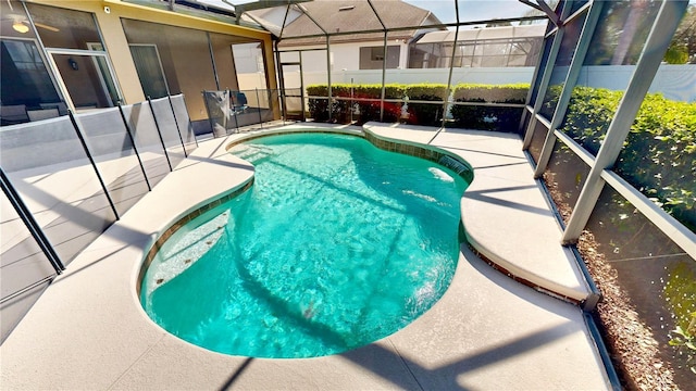 view of swimming pool featuring a lanai and a patio area