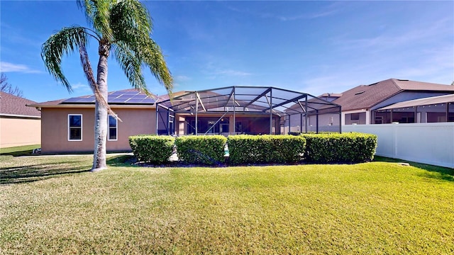 rear view of property with a lanai and a lawn