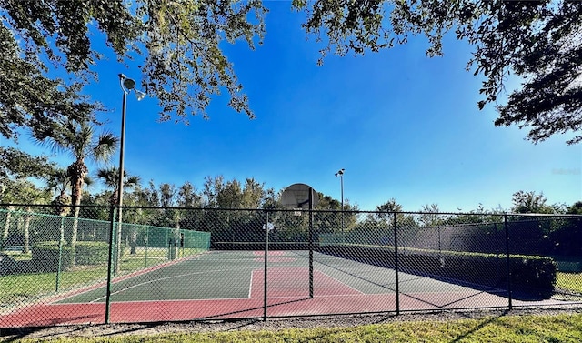 view of tennis court with basketball hoop