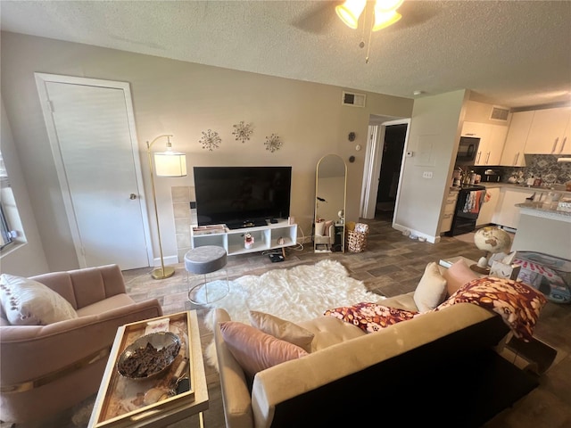 living room featuring a textured ceiling and ceiling fan