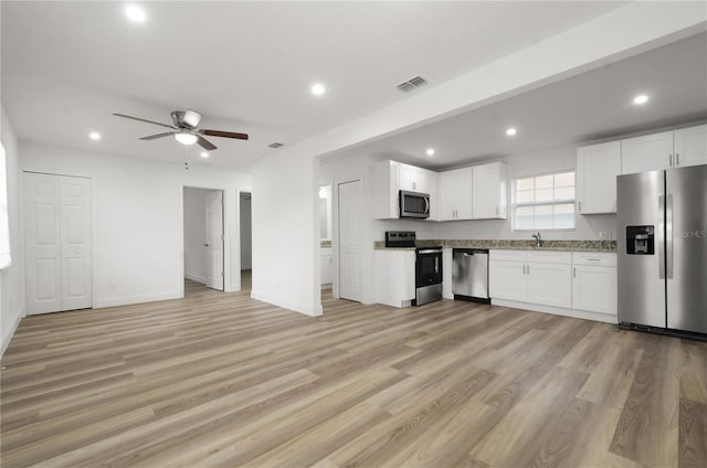 kitchen featuring visible vents, stainless steel appliances, light wood-style flooring, and white cabinetry