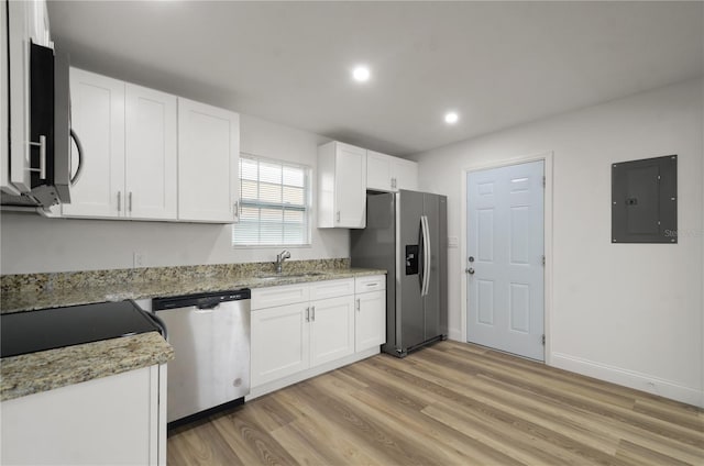 kitchen featuring stainless steel appliances, a sink, electric panel, and white cabinetry