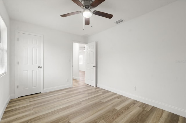 unfurnished bedroom featuring light wood finished floors, baseboards, visible vents, and ceiling fan