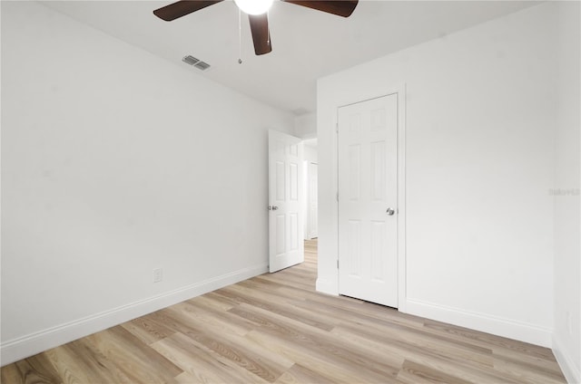 unfurnished bedroom with a ceiling fan, baseboards, visible vents, and light wood finished floors