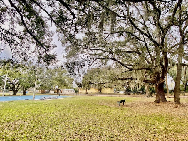 view of property's community with fence and a yard