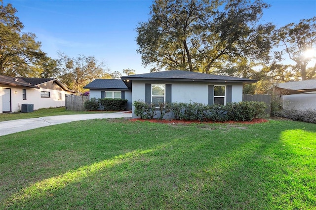 ranch-style house featuring central AC and a front lawn