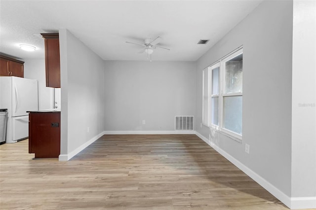 interior space with ceiling fan, light hardwood / wood-style flooring, and a textured ceiling