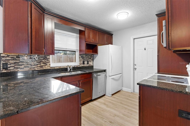 kitchen with dark stone counters, sink, a textured ceiling, appliances with stainless steel finishes, and tasteful backsplash