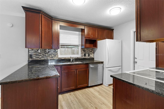 kitchen with dishwasher, sink, light hardwood / wood-style floors, a textured ceiling, and white fridge