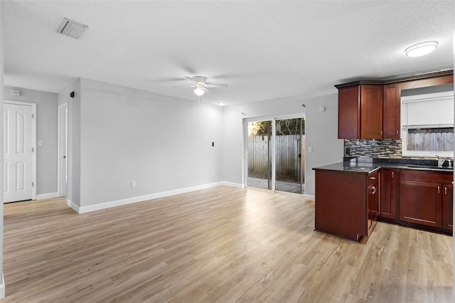 kitchen with backsplash, light hardwood / wood-style flooring, ceiling fan, and sink