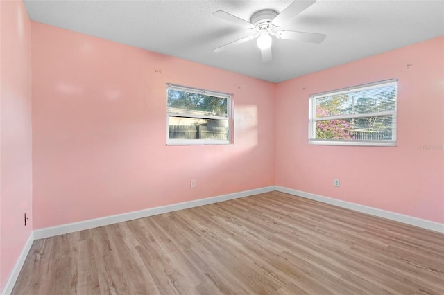 unfurnished room with ceiling fan, plenty of natural light, and light hardwood / wood-style floors