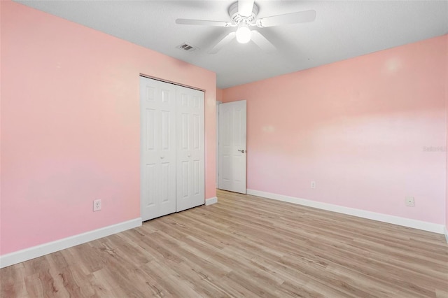 unfurnished bedroom featuring a closet, light hardwood / wood-style flooring, and ceiling fan