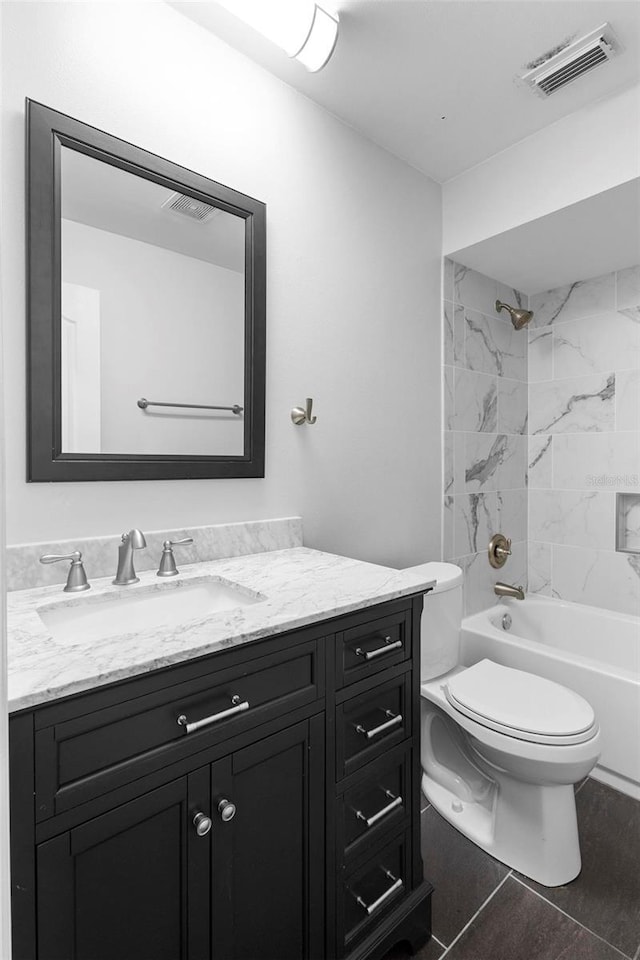 full bathroom with tile patterned flooring, vanity, toilet, and tiled shower / bath