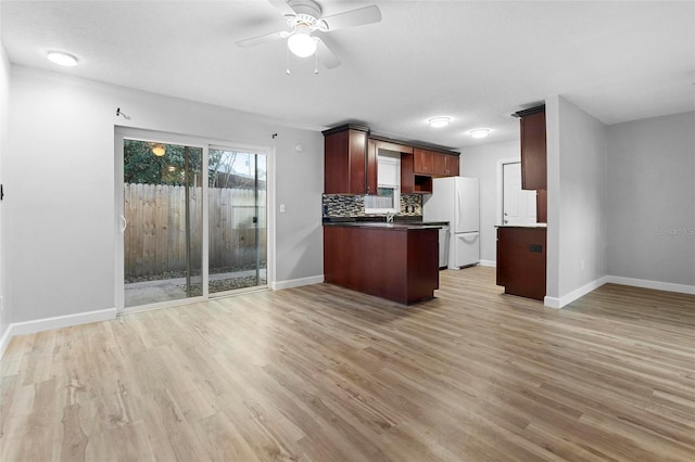 kitchen with decorative backsplash, ceiling fan, light wood-type flooring, and white refrigerator