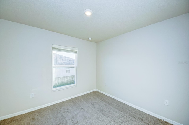 carpeted empty room featuring a textured ceiling