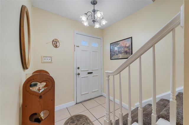 tiled entryway with a chandelier