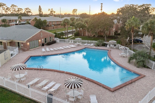 pool at dusk with a patio