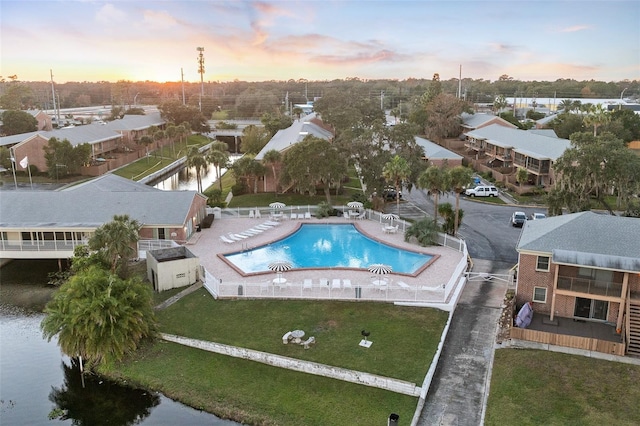 aerial view at dusk featuring a water view