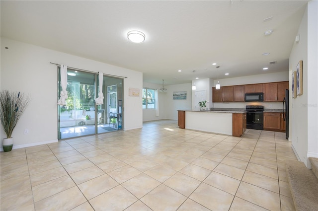 kitchen with pendant lighting, a center island, black appliances, light tile patterned floors, and a notable chandelier