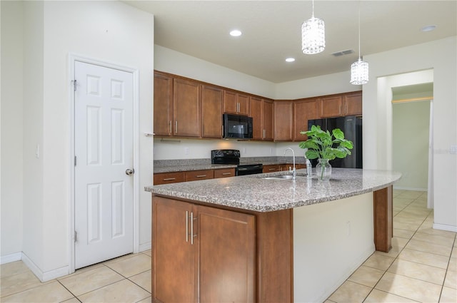 kitchen featuring pendant lighting, a center island with sink, black appliances, and sink