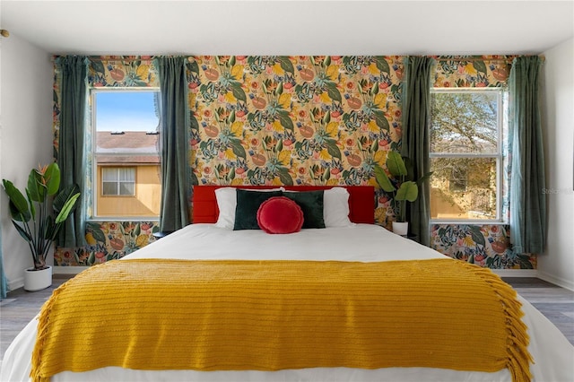 bedroom with hardwood / wood-style flooring and multiple windows