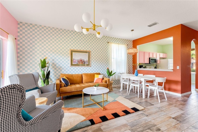 living room with a notable chandelier and light hardwood / wood-style floors