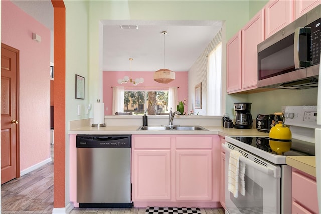 kitchen with sink, hanging light fixtures, a notable chandelier, and appliances with stainless steel finishes