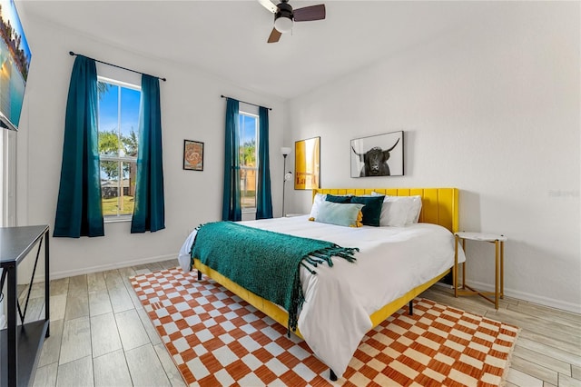 bedroom featuring multiple windows, ceiling fan, and light hardwood / wood-style flooring