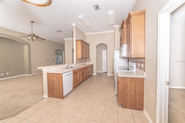 kitchen featuring kitchen peninsula, white appliances, light colored carpet, crown molding, and sink