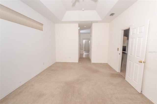 carpeted empty room featuring a tray ceiling