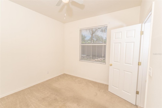 carpeted spare room with ceiling fan